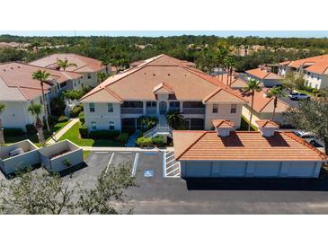 Beautiful condo with red tile roof, lush landscaping, and convenient parking at 7104 L Pavia Blvd # 7104, Venice, FL 34292