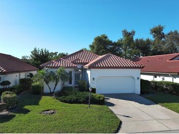Charming single-story home with a red tile roof, well-manicured lawn, and attached two-car garage at 904 Harbor Town Dr, Venice, FL 34292