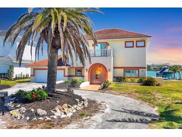 Beautiful two-story waterfront home featuring a red tile roof, arched entryway, and lush landscaping at 919 Key Way, Nokomis, FL 34275