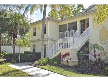 Inviting exterior showcasing the two-story home with well-manicured landscaping and white stair rails at 1000 Gardens Edge Dr # 1023, Venice, FL 34285