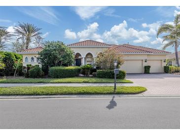 Charming home featuring a red tile roof, well-manicured landscaping, and a spacious two-car garage at 101 Portofino Dr, North Venice, FL 34275