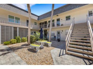 Charming courtyard with stone benches and lush landscaping, providing a tranquil outdoor space at 200 Park N Blvd # 108, Venice, FL 34285