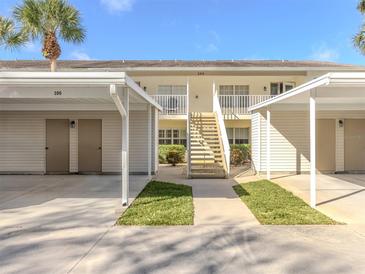 A view of the building exterior showcasing its architecture, landscaping, and covered parking with access to the units at 206 Silver Lake Dr # 105, Venice, FL 34292