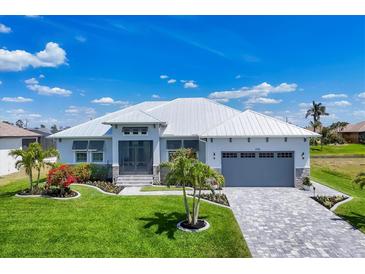 Beautiful single-story home featuring lush landscaping, a gray garage door, and a pristine white exterior at 226 W Pine Valley Ln, Rotonda West, FL 33947