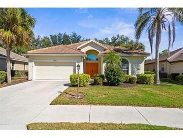 Charming single-story home with lush landscaping, a barrel tile roof, and a two-car garage at 2292 Harrier Way, Nokomis, FL 34275