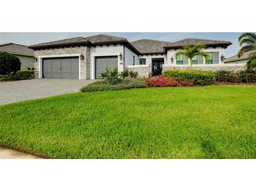 Attractive home exterior with a green lawn, mature landscaping, and a multi-car garage at 265 Bocelli Dr, Nokomis, FL 34275