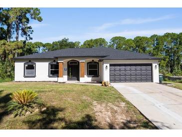 Charming single-story home featuring a well-manicured lawn and a two-car garage at 3470 Elias Cir, North Port, FL 34288