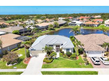 Stunning waterfront home with well-manicured lawn, lovely landscaping, and community water feature in the backyard at 863 Macaw Cir, Venice, FL 34285