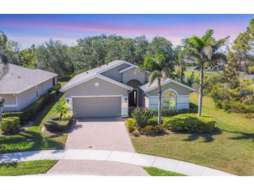 Charming single-story home featuring a brick driveway, attached garage, and well-maintained landscaping at 9312 Coachman Dr, Venice, FL 34293