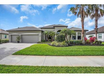 Charming single-story home with well-maintained landscaping, palm trees, and a paver driveway at 988 145Th Street Ne Cir, Bradenton, FL 34212