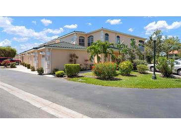 Beautiful peach-colored condo featuring tropical landscaping and elegant architecture, enhancing curb appeal at 1007 Gondola Park Dr # 1007, Venice, FL 34292