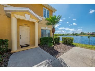 Inviting front entrance with well-maintained landscaping and a peaceful lake view at 12983 Tigers Eye Dr, Venice, FL 34292