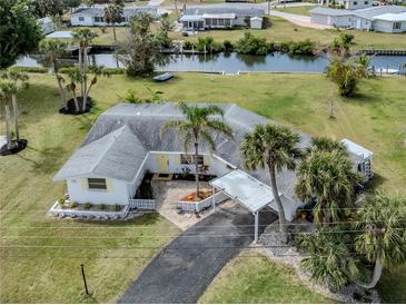Charming waterfront home with lush landscaping, a covered carport, and easy access to the canal for boating and relaxation at 504 Buena Vista Dr, Nokomis, FL 34275