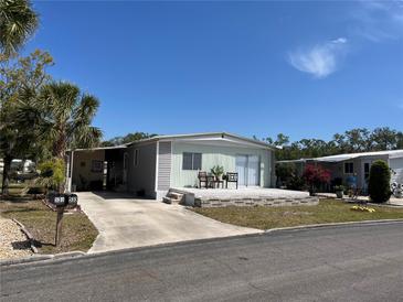 Charming single-story home with a well-maintained lawn and a cozy front deck with outdoor seating at 533 Cervina N Dr # 773, Venice, FL 34285