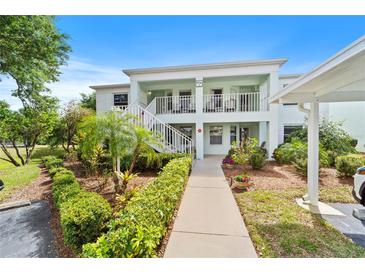 Inviting two-story condo featuring well-maintained landscaping and a charming walkway leading to the entrance at 5725 Greenwood Ave # 1201, North Port, FL 34287