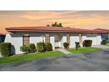 Charming single-story home with a red tile roof, manicured lawn and mature landscaping at 846 Senda Plata # 26, Venice, FL 34293