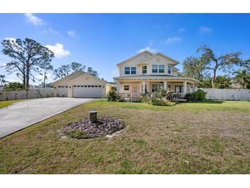 Beautiful two-story home with a long driveway, well-kept lawn, covered porch, and a detached garage at 915 Citrus Rd, Venice, FL 34293