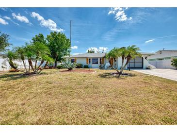 Charming single-story home with well-maintained landscaping and mature palm trees under a sunny sky at 1281 Wilson Dr, Englewood, FL 34224