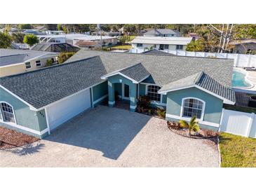 Charming single-story home with lush landscaping, a gravel driveway, and an inviting entrance at 1440 Overbrook Rd, Englewood, FL 34223