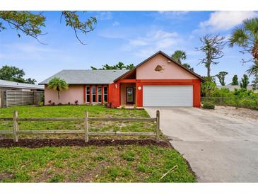 Charming single-story home with a two-car garage, colorful accents, and a well-manicured lawn at 304 Beach Rd, Venice, FL 34285