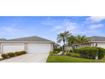 Charming single-story home featuring a two-car garage, well-manicured landscaping, and mature palm trees at 3419 Lakewood Blvd, North Port, FL 34287