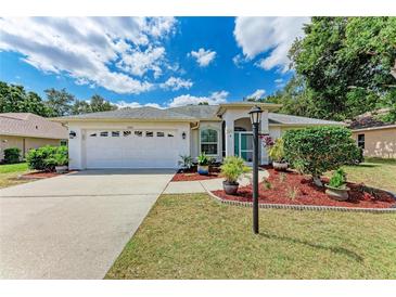 Charming single-story home featuring a well-maintained lawn, two-car garage, and beautiful landscaping at 5766 Stone Pointe Dr, Sarasota, FL 34233