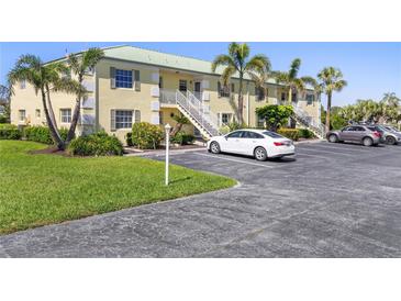 Inviting two-story condo featuring a well-maintained facade, lush landscaping and parking at 942 Capri Isles Blvd # 105, Venice, FL 34292