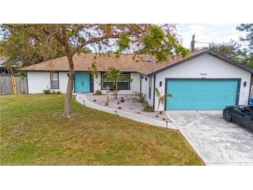 Charming single-story home featuring a bright turquoise garage door and entry in a well-maintained yard at 1008 Euclid Rd, Venice, FL 34293
