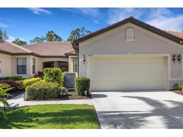 Charming home featuring a two-car garage, well-kept lawn, and lush landscaping at 11007 Batello Dr, Venice, FL 34292