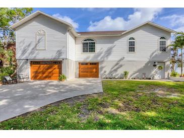 Inviting home featuring a three-car garage, manicured lawn, and charming curb appeal at 1500 Lemon Bay Dr, Venice, FL 34293