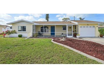 Charming single-story home with well-maintained lawn, colorful landscaping, and screened in porch at 1537 Overbrook Rd, Englewood, FL 34223