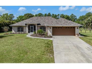 Inviting single-story home with a well-manicured lawn and a two-car garage at 1653 Albino St, Nokomis, FL 34275