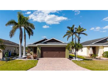 Charming single Gathering home featuring a brick paved driveway and lush tropical landscaping at 4835 San Ortebello Dr, Bradenton, FL 34208