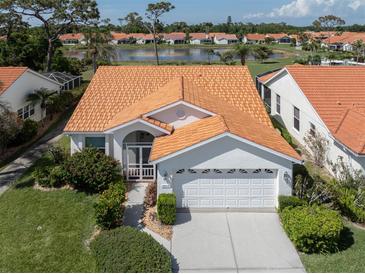 Beautiful single-story home with a bright terra cotta roof, manicured lawn, and attached two car garage at 4843 Orange Tree Pl, Venice, FL 34293