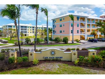 Beautiful Cape Haze resort entrance with palm trees and colorful buildings on a sunny day at 8405 Placida Rd # 206, Placida, FL 33946