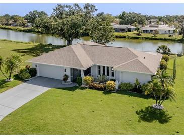 Charming single-story home with a well-manicured lawn and waterfront view at 1232 Pine Needle Rd, Venice, FL 34285