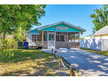 Charming cottage exterior with screened-in porch, and lush landscaping at 140 Avenida De La Isla, Nokomis, FL 34275