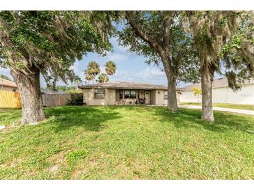 Inviting single-story home with a well-maintained lawn, mature trees, and an idyllic, peaceful setting at 1609 Kirkwood St, North Port, FL 34288