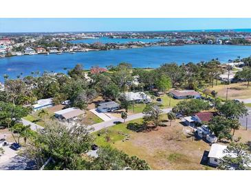Beautiful aerial view of waterfront homes, lush landscaping, and stunning blue water in the background at 203 Palm Ave, Nokomis, FL 34275