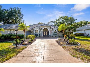 Beautiful single-Gathering home featuring a well-manicured lawn, mature trees, and a grand entrance at 2187 Calusa Lakes Blvd, Nokomis, FL 34275
