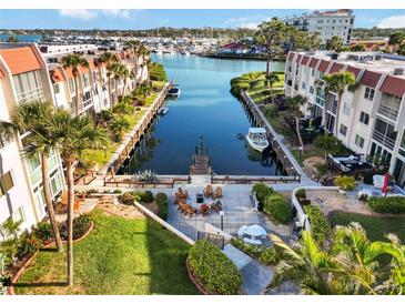 Beautiful aerial view overlooking a canal with a dock and waterfront condominium community with a courtyard and outdoor seating at 230 Santa Maria St # 333, Venice, FL 34285