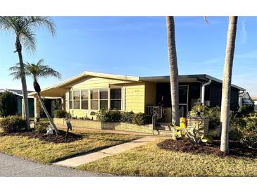 Charming single-story home featuring mature landscaping and a welcoming front porch at 262 Mariner Dr, North Port, FL 34287