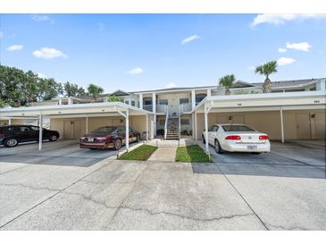 A lovely condo unit features assigned covered parking spots and mature landscaping at 414 Laurel Lake Dr # 203, Venice, FL 34292
