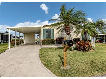 Charming home featuring a covered carport, lush landscaping, and inviting curb appeal at 423 Pirates Pt, North Port, FL 34287