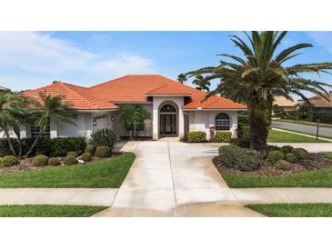 Charming single-story home featuring a red tile roof, lush landscaping, and a welcoming entrance, providing great curb appeal at 4641 Gaeta Dr, Venice, FL 34293