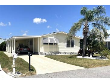 Inviting home with a car port, palm tree, manicured lawn, and a front-facing mailbox at 537 Amberjack Dr, North Port, FL 34287
