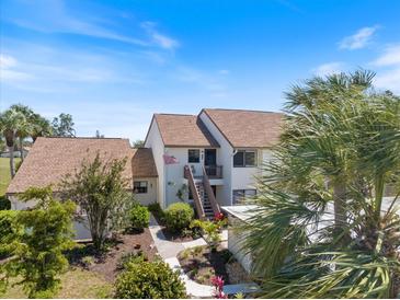 Inviting two-story condo with tropical landscaping, offering a serene and picturesque curb appeal at 726 Bird Bay W Dr # 153, Venice, FL 34285