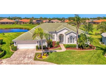 Inviting home with a well-manicured lawn, mature palm trees, and lush landscaping creates a picturesque curb appeal at 854 Blue Crane Dr, Venice, FL 34285