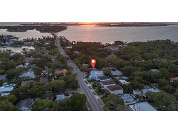 Aerial view of home showing location close to the water with mature landscaping and tree coverage at 1629 Siesta Dr, Sarasota, FL 34239