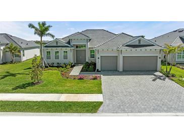 Charming single-story home featuring a tile roof, a two-car garage, and meticulously landscaped front yard at 17324 Sandpearl Rd, Venice, FL 34293